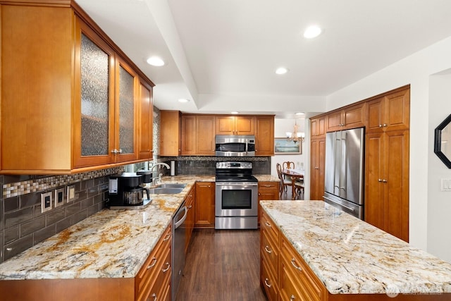 kitchen with stainless steel appliances, dark wood finished floors, and brown cabinetry