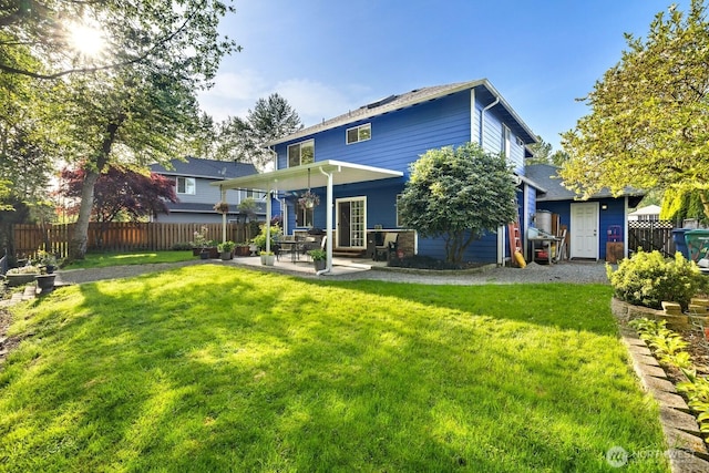 back of house featuring a yard, fence, and a patio area