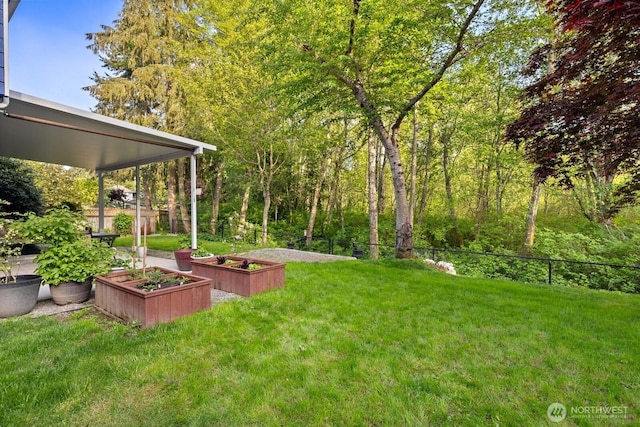 view of yard featuring fence and a garden