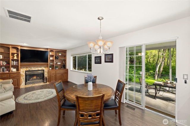 dining room with dark wood-type flooring, a chandelier, and visible vents