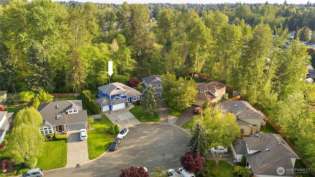 bird's eye view featuring a wooded view and a residential view