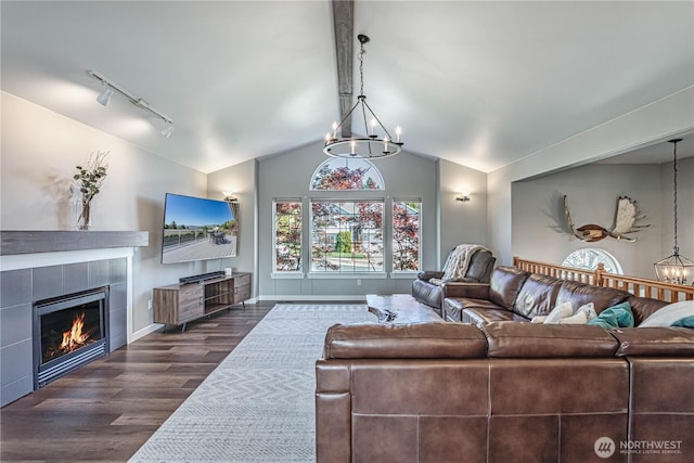 living room with vaulted ceiling, dark wood-style flooring, a fireplace, a chandelier, and baseboards