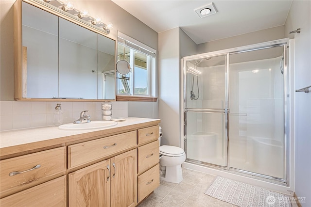 bathroom featuring tile patterned floors, toilet, tasteful backsplash, and a stall shower
