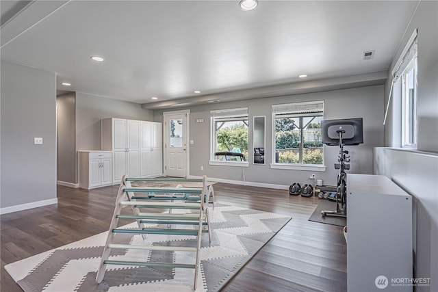 exercise room featuring baseboards, dark wood-style floors, visible vents, and recessed lighting
