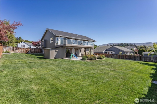rear view of house featuring a fenced backyard, a patio, and a yard