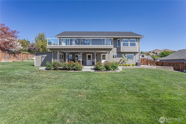 rear view of property with a patio, a storage unit, central AC unit, a fenced backyard, and a yard