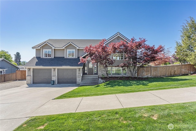 view of front of home featuring driveway, brick siding, fence, an attached garage, and a front lawn