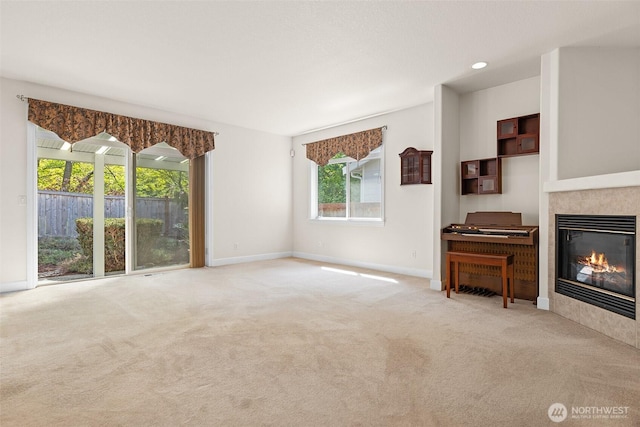 unfurnished living room with baseboards, carpet, and a tile fireplace