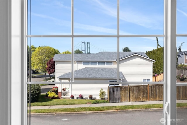 view of front facade with fence and roof with shingles
