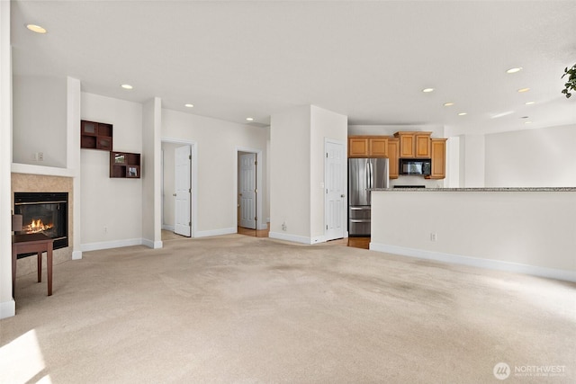 unfurnished living room with baseboards, light carpet, recessed lighting, and a tile fireplace