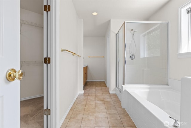 full bathroom with a shower stall, a walk in closet, a bath, and vanity