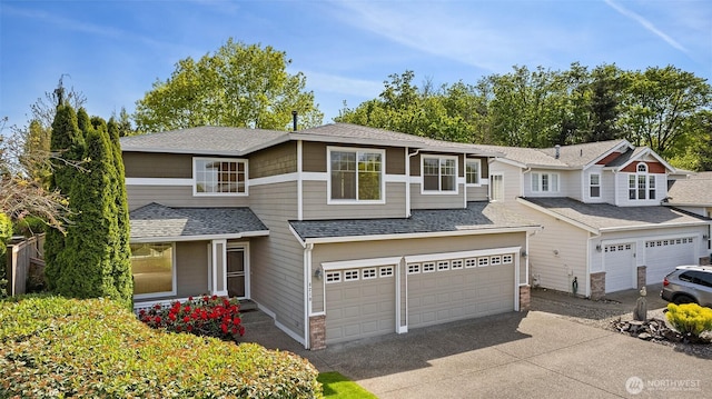 view of front of property with an attached garage, a shingled roof, and driveway
