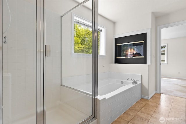 full bath with tile patterned flooring, a shower stall, and a garden tub