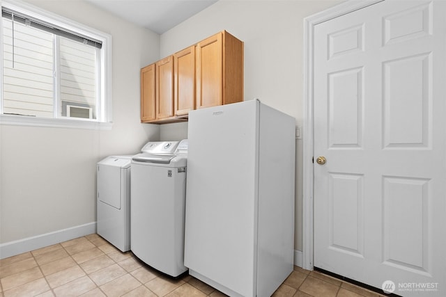 laundry area with baseboards, cabinet space, washing machine and dryer, and light tile patterned flooring