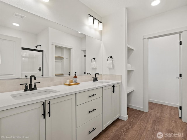 1349 Bill Ave, Walla Walla, WA 99362 - bathroom featuring wood finished floors, double vanity, decorative backsplash, recessed lighting, and a shower