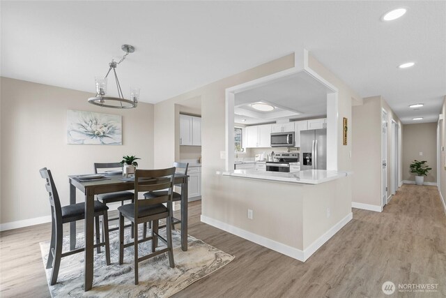dining area with light wood-style floors, baseboards, and recessed lighting