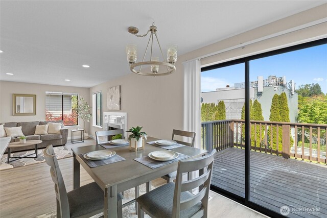 dining room with recessed lighting, an inviting chandelier, and light wood-type flooring