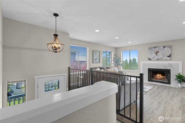 hallway featuring recessed lighting, a chandelier, an upstairs landing, and wood finished floors