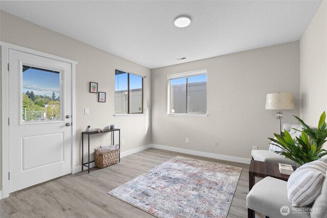 sitting room featuring baseboards, visible vents, and wood finished floors