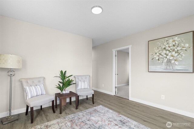 living area with baseboards and wood finished floors