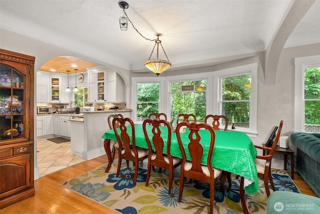 505 S 8th, Shelton, WA 98584 - dining space featuring plenty of natural light, light wood-style flooring, arched walkways, and a textured ceiling