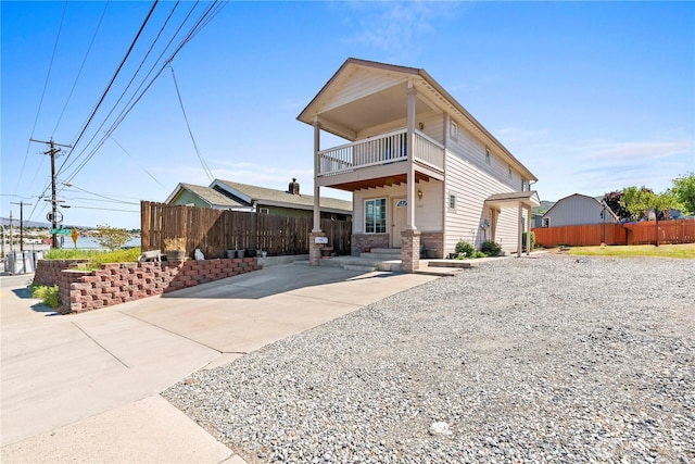 view of front of house featuring fence and a balcony