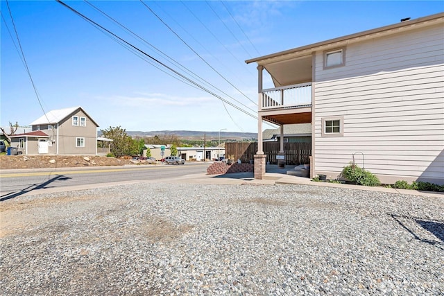 view of yard featuring fence and a balcony