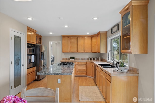 6211 116th Ave NE, Kirkland, WA 98033 - kitchen with stainless steel appliances, a sink, a center island, light wood finished floors, and glass insert cabinets