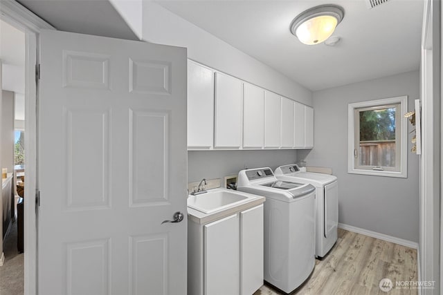 6211 116th Ave NE, Kirkland, WA 98033 - laundry area with washer and clothes dryer, cabinet space, plenty of natural light, and light wood-type flooring