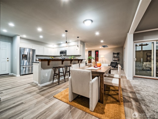 dining room with baseboards, light wood-type flooring, and recessed lighting
