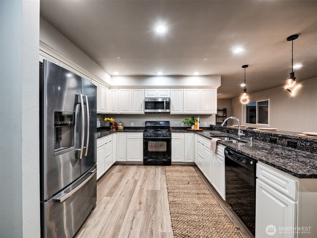 kitchen featuring light wood-type flooring, a sink, black appliances, a peninsula, and white cabinetry