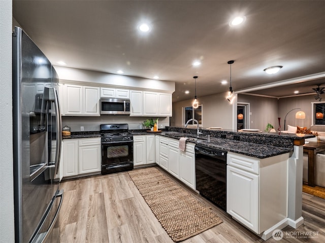 kitchen with a sink, light wood-style flooring, a peninsula, and black appliances