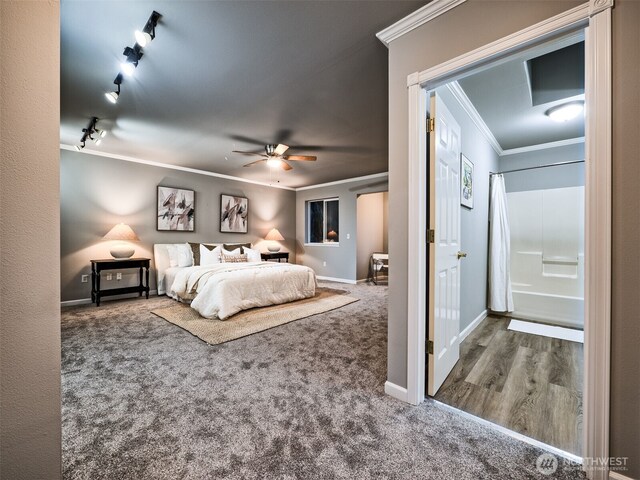 carpeted bedroom with crown molding, baseboards, ceiling fan, and track lighting