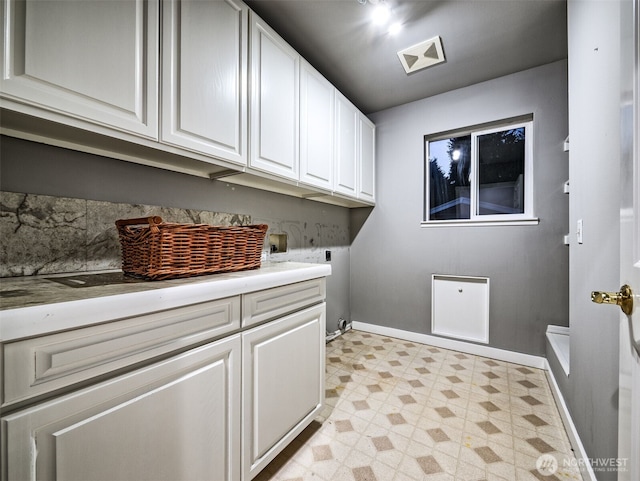 clothes washing area featuring cabinet space, hookup for a washing machine, baseboards, electric dryer hookup, and light floors