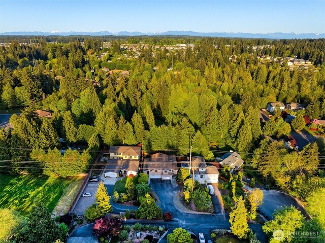 birds eye view of property with a forest view and a mountain view
