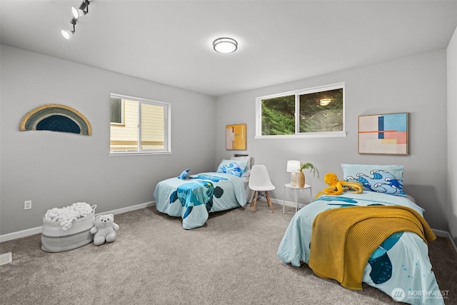 carpeted bedroom featuring baseboards and multiple windows