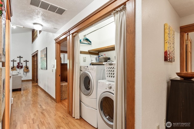 11451 O Ave, Anacortes, WA 98221 - laundry room featuring laundry area, a textured ceiling, light wood-style flooring, visible vents, and washing machine and dryer