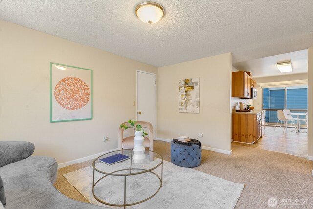 living room with a textured ceiling, baseboards, and light carpet