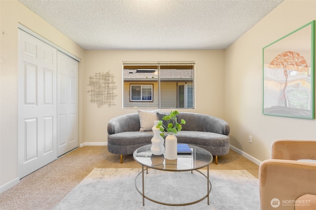 living area with carpet flooring, a textured ceiling, and baseboards