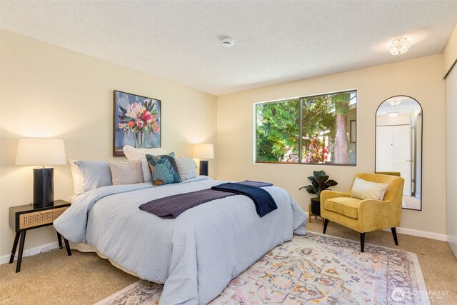 bedroom with carpet floors, a textured ceiling, and baseboards