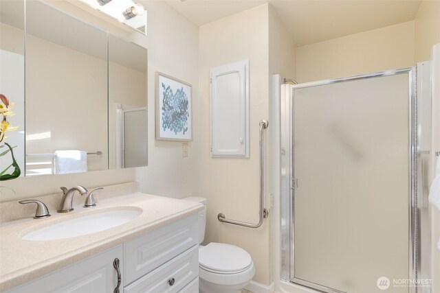 bathroom with a shower stall, vanity, and toilet