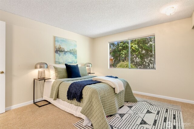 carpeted bedroom featuring a textured ceiling and baseboards