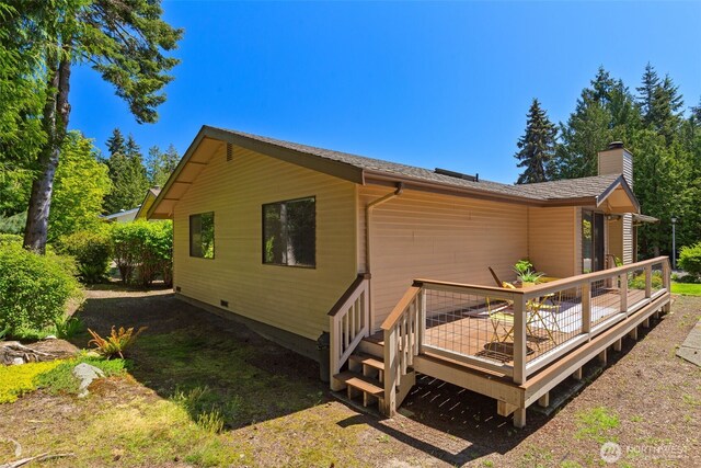 back of property featuring a deck and a chimney