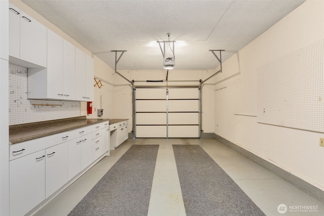 garage with baseboards and a garage door opener