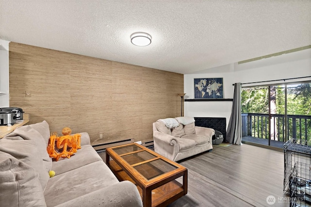 4008 S 158th St Unit J, Tukwila, WA 98188 - living area with a textured ceiling, wood finished floors, a baseboard radiator, and a fireplace
