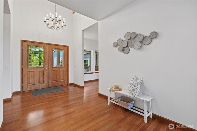 161 E Heron Cv, Shelton, WA 98584 - entryway with a towering ceiling, baseboards, a notable chandelier, and light wood-style floors