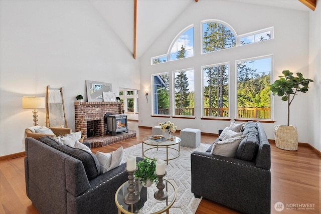 161 E Heron Cv, Shelton, WA 98584 - living room featuring baseboards, high vaulted ceiling, wood finished floors, and a wood stove