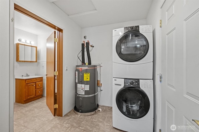 clothes washing area with light tile patterned flooring, laundry area, a sink, water heater, and stacked washer / dryer