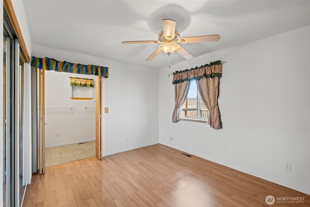 spare room featuring visible vents, ceiling fan, and light wood-type flooring