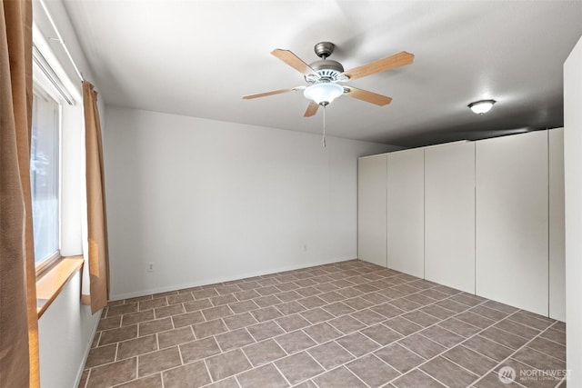 interior space featuring tile patterned flooring and ceiling fan